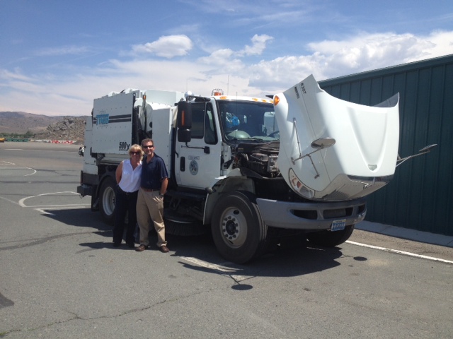 Two members of NDEP staff stand in front of Carson CIty's new Tymco street sweeper